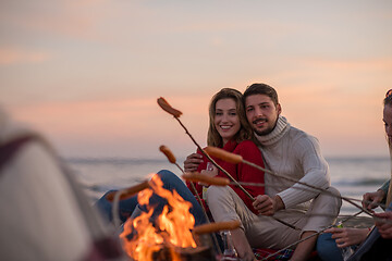 Image showing Group Of Young Friends Sitting By The Fire at beach