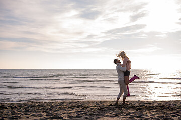 Image showing Loving young couple on a beach at autumn sunny day