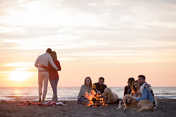 Image showing Couple enjoying with friends at sunset on the beach