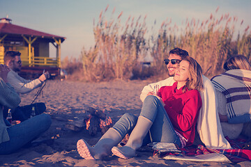 Image showing Couple enjoying with friends at sunset on the beach