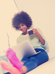 Image showing black woman in the living room on the floor