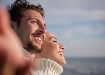 Image showing Loving young couple on a beach at autumn sunny day