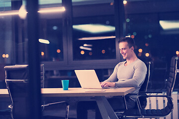 Image showing man working on laptop in dark office