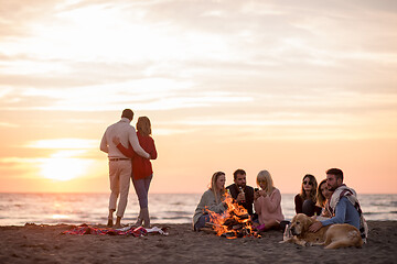 Image showing Couple enjoying with friends at sunset on the beach