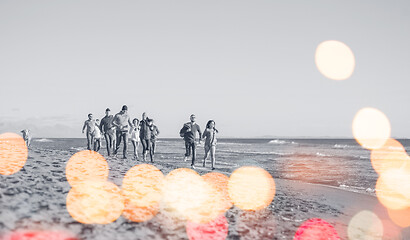 Image showing Group of friends running on beach during autumn day