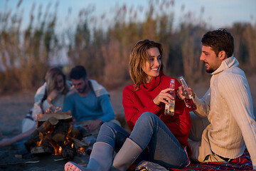 Image showing Couple enjoying with friends at sunset on the beach