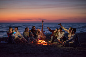 Image showing a group of friends enjoying bonfire on beach