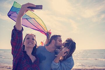 Image showing Group of friends making selfie on beach during autumn day