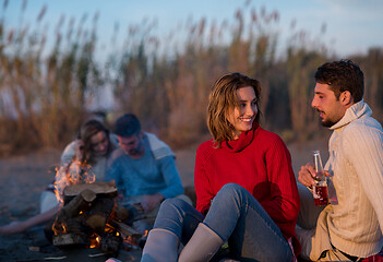 Image showing Couple enjoying with friends at sunset on the beach