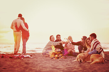 Image showing Couple enjoying with friends at sunset on the beach