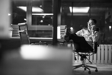 Image showing businessman using mobile phone in dark office