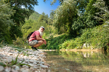 Image showing Hiker is resting by the stream