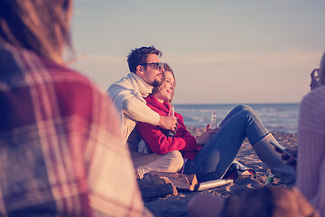 Image showing Couple enjoying with friends at sunset on the beach