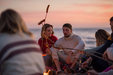 Image showing Group Of Young Friends Sitting By The Fire at beach