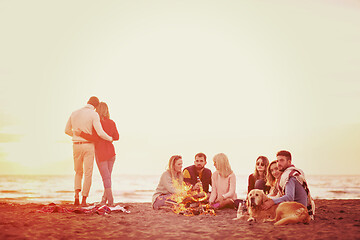 Image showing Couple enjoying with friends at sunset on the beach