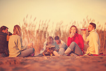 Image showing Couple enjoying with friends at sunset on the beach