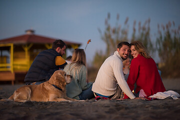 Image showing Couple enjoying with friends at sunset on the beach