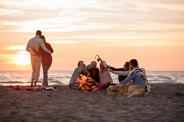 Image showing Couple enjoying with friends at sunset on the beach