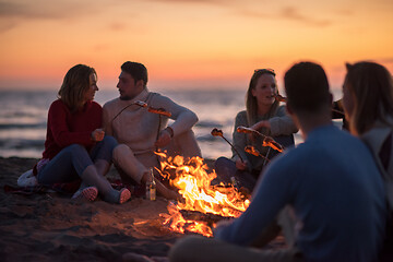 Image showing Group Of Young Friends Sitting By The Fire at beach