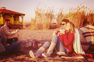 Image showing Couple enjoying with friends at sunset on the beach