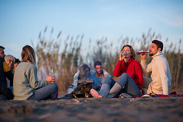 Image showing Couple enjoying with friends at sunset on the beach