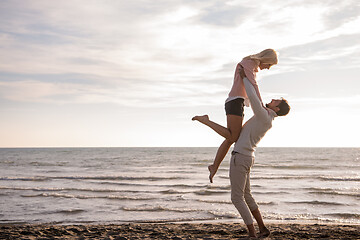 Image showing Loving young couple on a beach at autumn sunny day