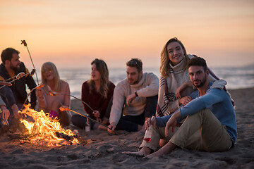 Image showing Group Of Young Friends Sitting By The Fire at beach