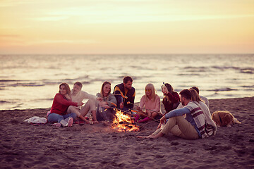 Image showing Group Of Young Friends Sitting By The Fire at beach