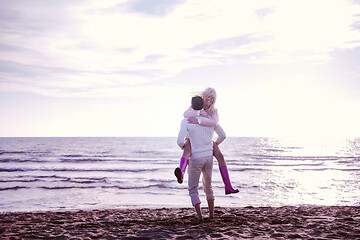 Image showing Loving young couple on a beach at autumn sunny day