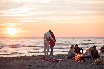 Image showing Couple enjoying with friends at sunset on the beach