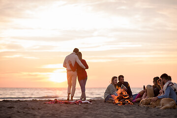 Image showing Couple enjoying with friends at sunset on the beach