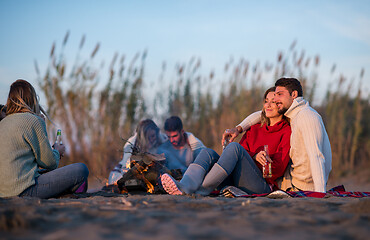 Image showing Couple enjoying with friends at sunset on the beach