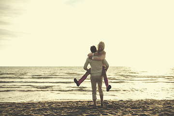 Image showing Loving young couple on a beach at autumn sunny day