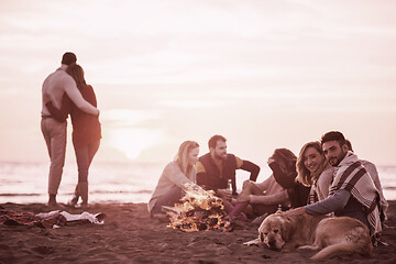 Image showing Couple enjoying with friends at sunset on the beach