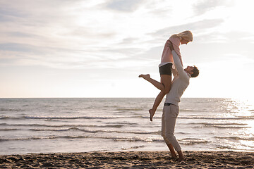 Image showing Loving young couple on a beach at autumn sunny day