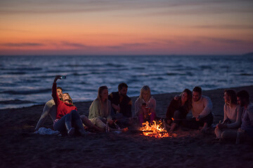 Image showing a group of friends enjoying bonfire on beach