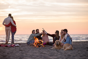 Image showing Couple enjoying with friends at sunset on the beach