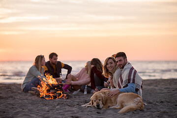 Image showing Couple enjoying with friends at sunset on the beach