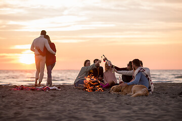 Image showing Couple enjoying with friends at sunset on the beach