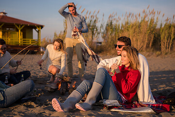 Image showing Couple enjoying with friends at sunset on the beach