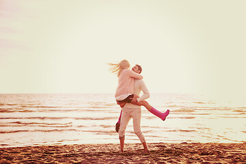 Image showing Loving young couple on a beach at autumn sunny day