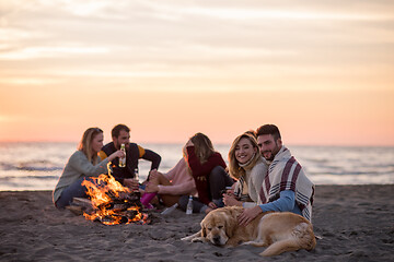 Image showing Couple enjoying with friends at sunset on the beach