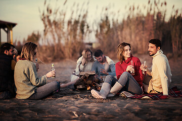 Image showing Couple enjoying with friends at sunset on the beach