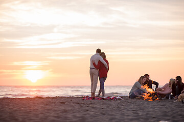 Image showing Couple enjoying with friends at sunset on the beach