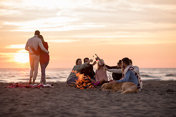 Image showing Couple enjoying with friends at sunset on the beach