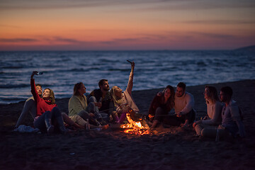 Image showing a group of friends enjoying bonfire on beach