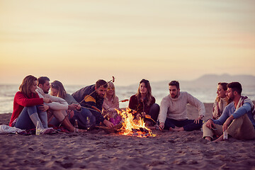 Image showing Group Of Young Friends Sitting By The Fire at beach