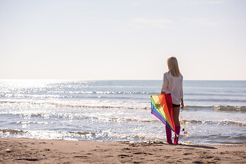 Image showing Young Woman with kite at beach on autumn day