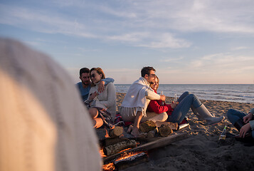 Image showing Couple enjoying with friends at sunset on the beach