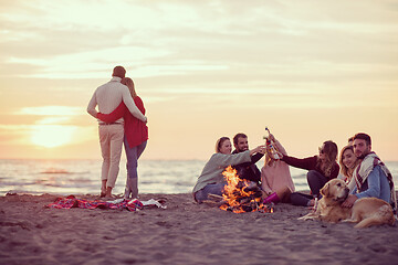 Image showing Couple enjoying with friends at sunset on the beach